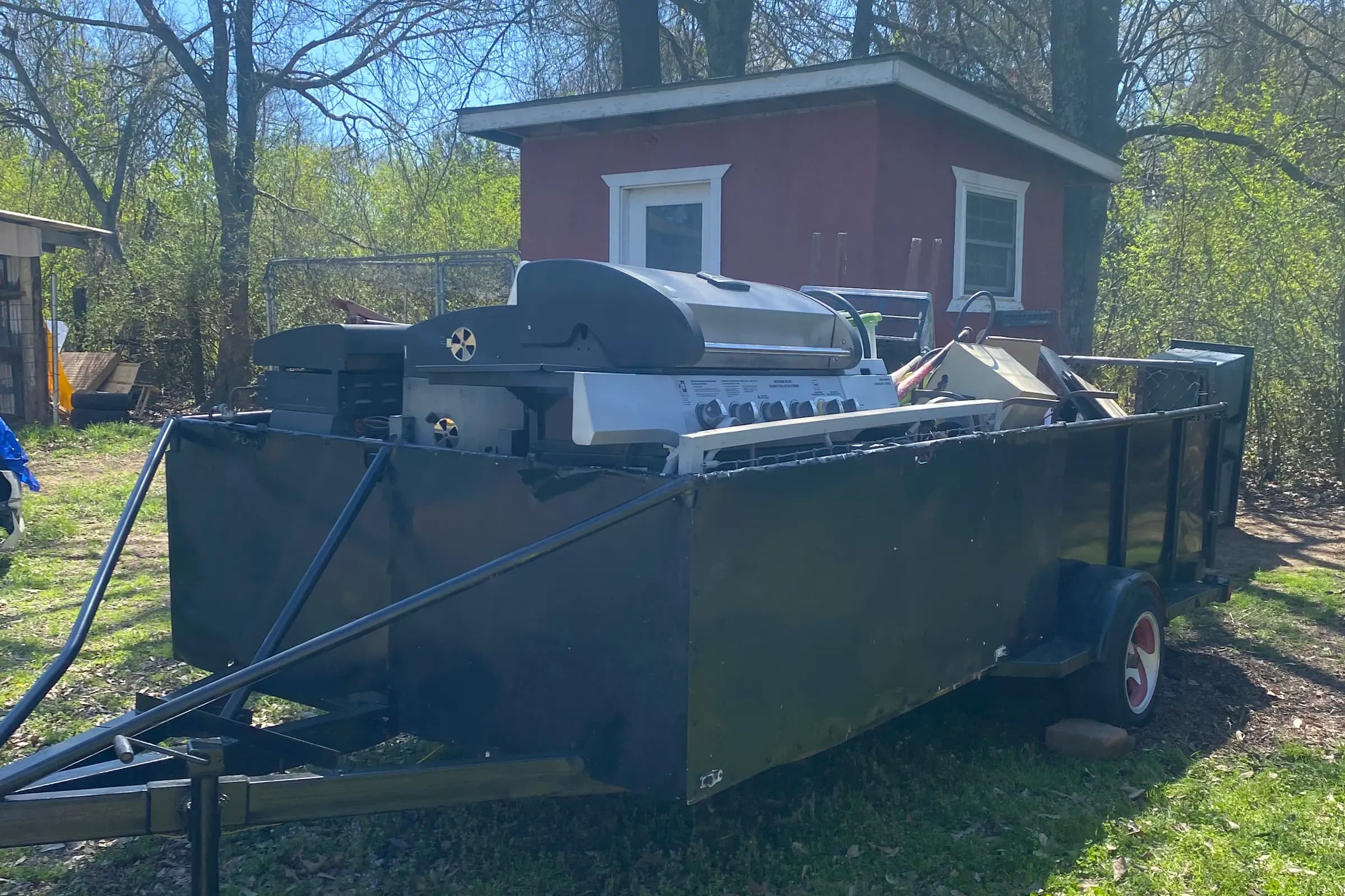 Trailer loaded with a grill, appliances and household junk, ready to haul